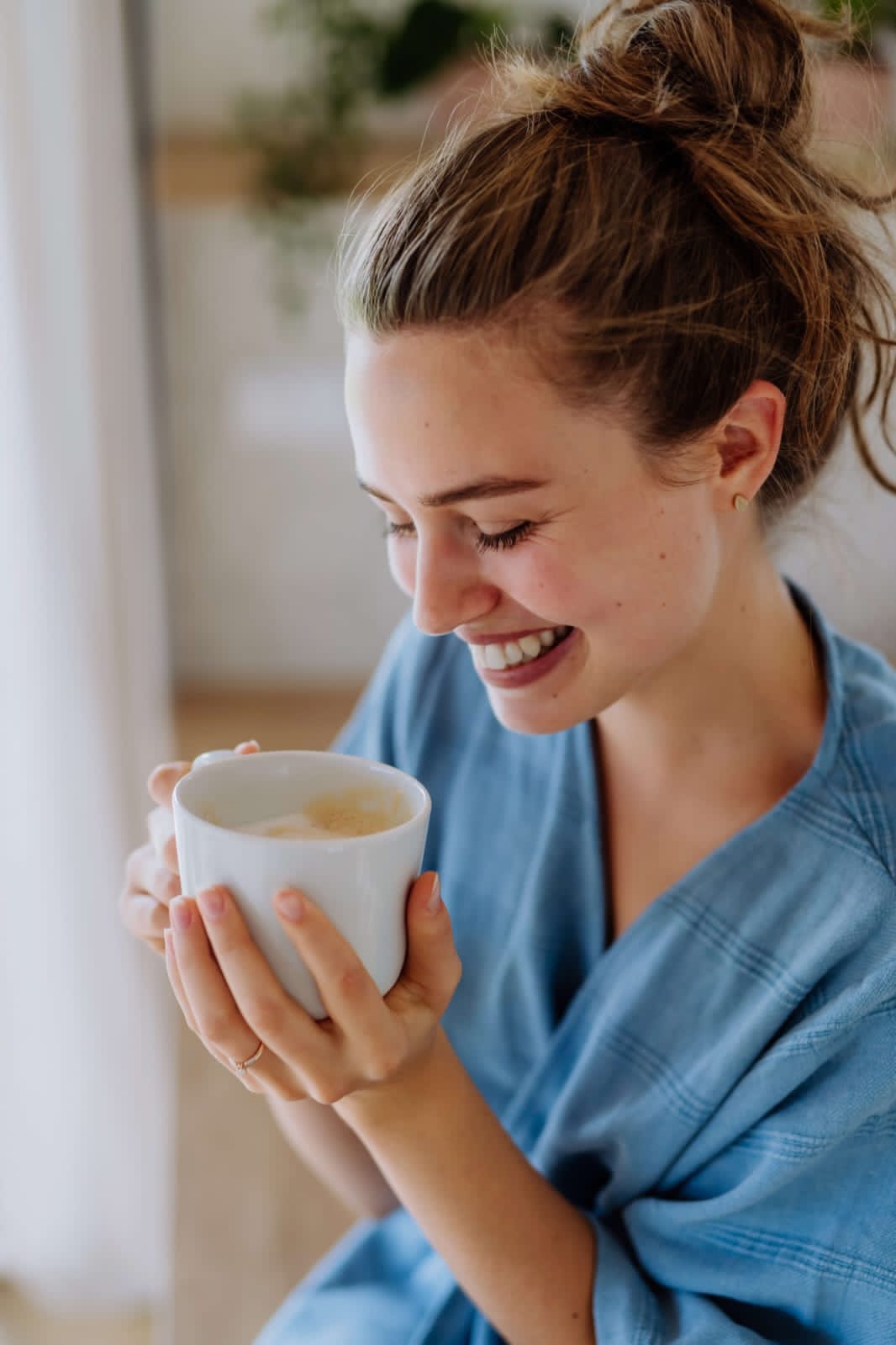 At FullyKnow, A happy woman with a cup of coffee